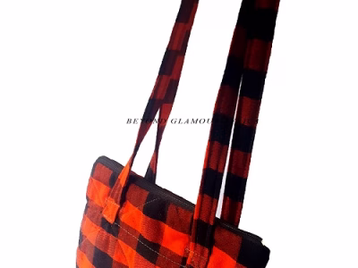 A black and red sling bag and brown wooden bracelet