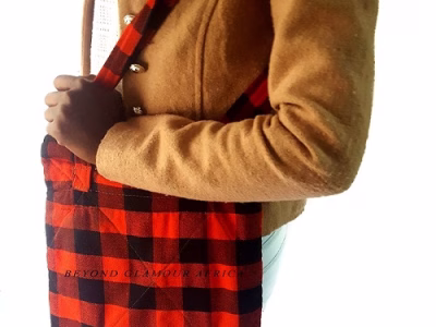 A black and red sling bag and brown wooden bracelet