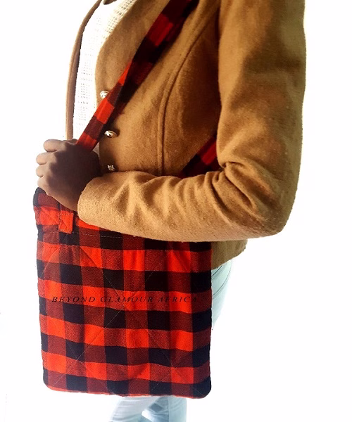 A black and red sling bag and brown wooden bracelet
